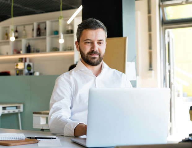Businessman using a payslip portal on his laptop